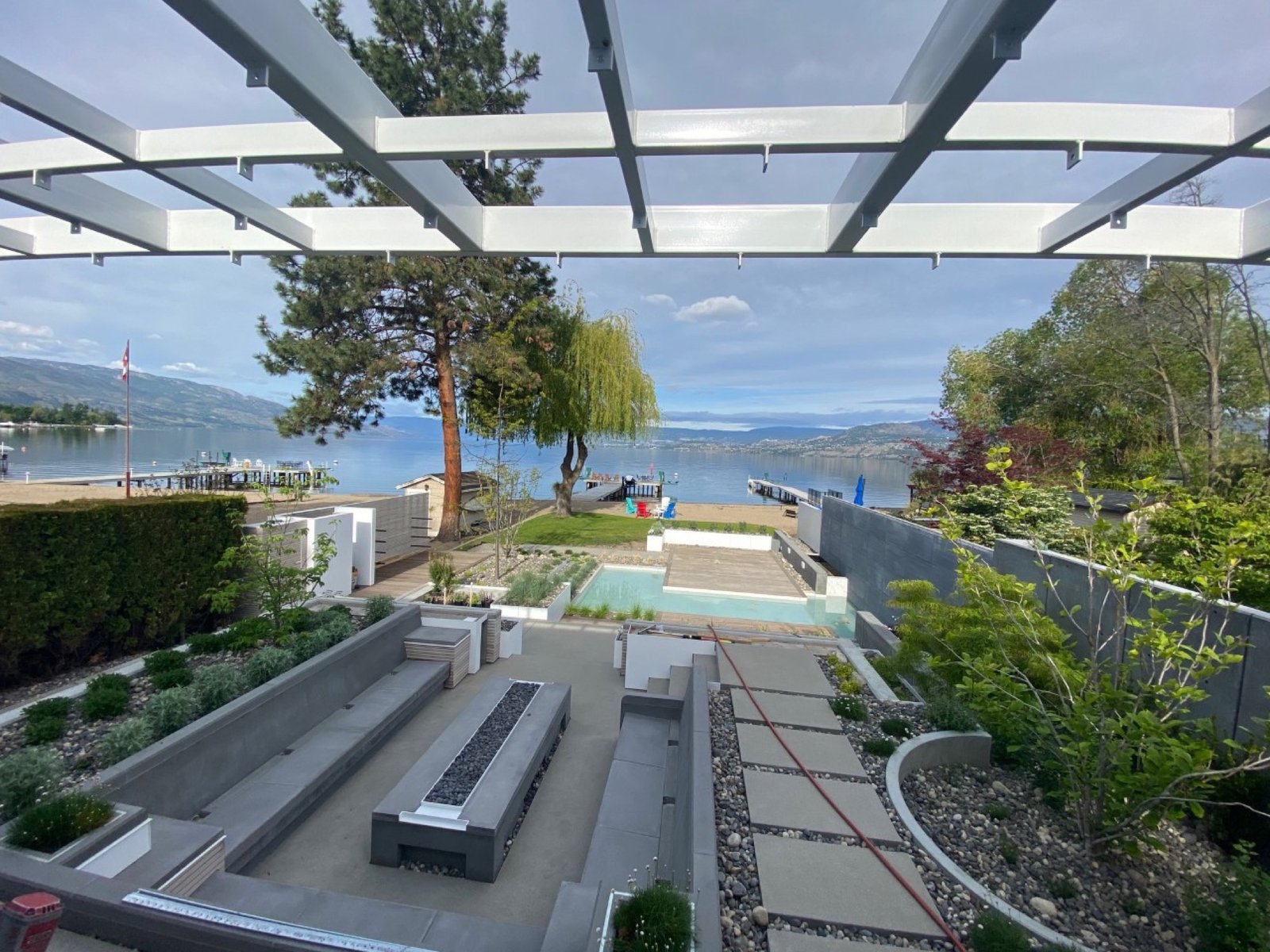 Sunken concrete lounge and hardscape under a steel pergola