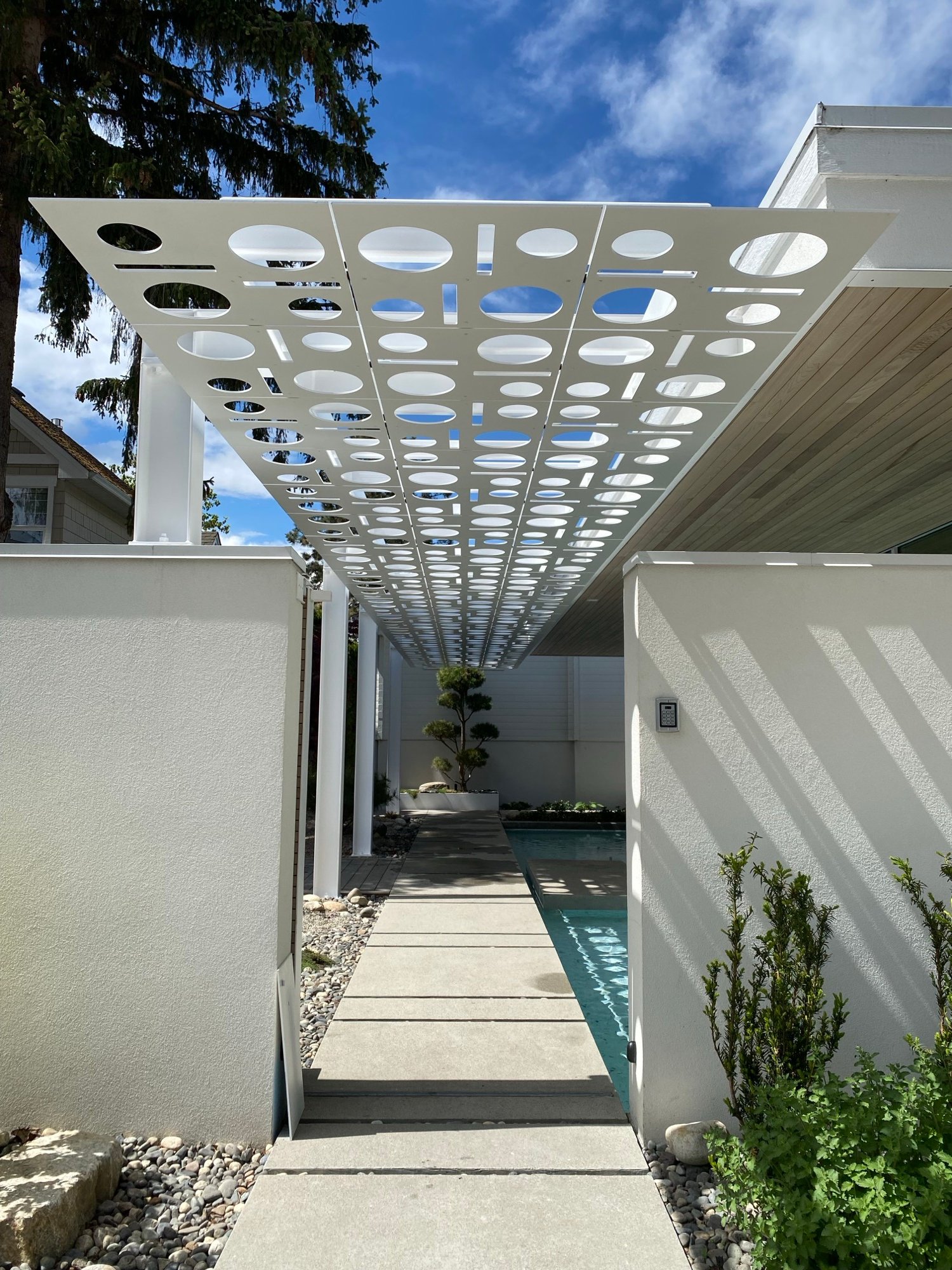 Perforated metal awning over a pool walkway